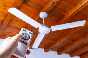 person-uses-remote-to-turn-on-ceiling-fan
